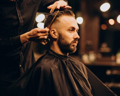 Young man at barbershop trimming hair